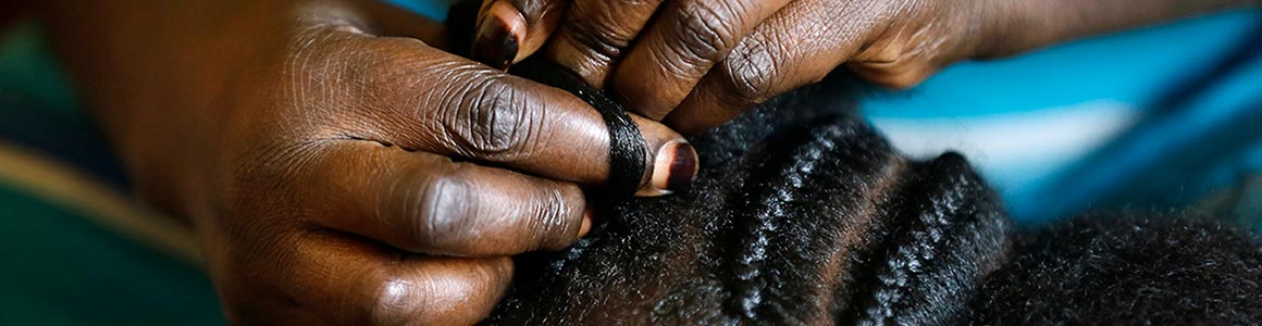 closeup image of an individuals hands braiding hair