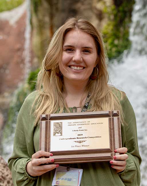 Image of Rebekah Yeagley holding 1st place APEE plaque