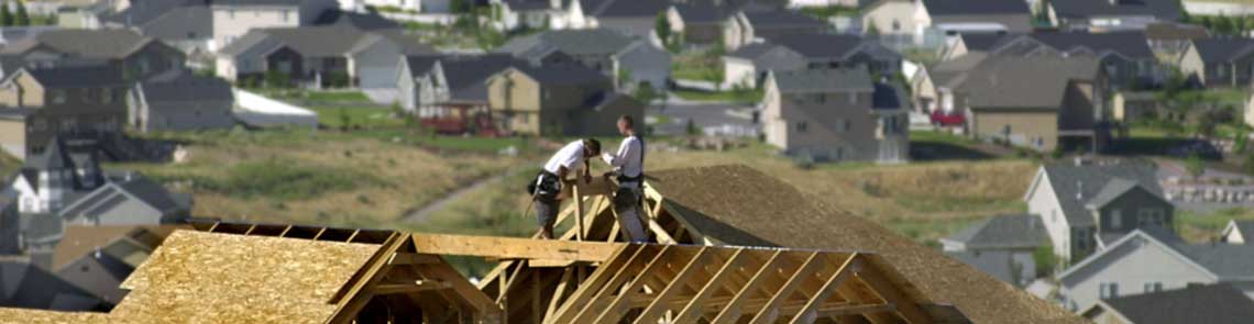 image of two construction workers on the roof of an unfinished home