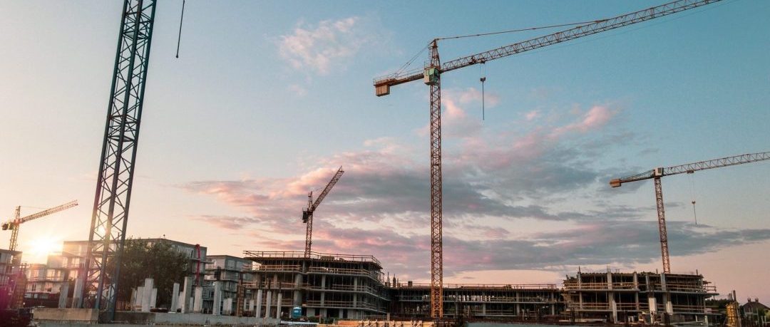 Building under construction with several cranes filling the skyline